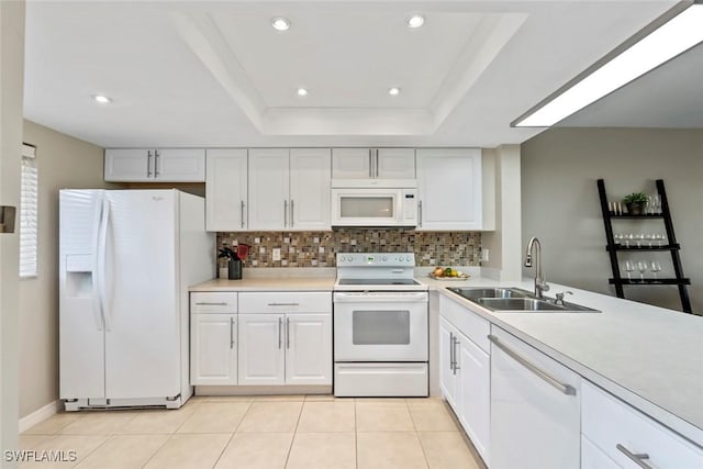 kitchen with white appliances, light countertops, white cabinets, and a sink