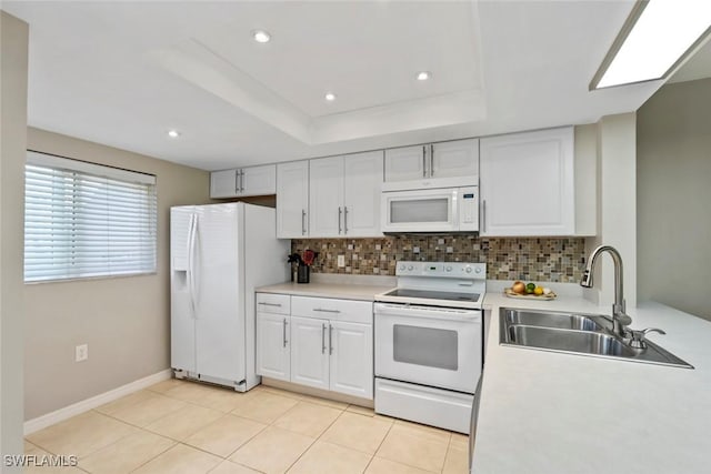 kitchen featuring tasteful backsplash, white appliances, white cabinets, and a sink