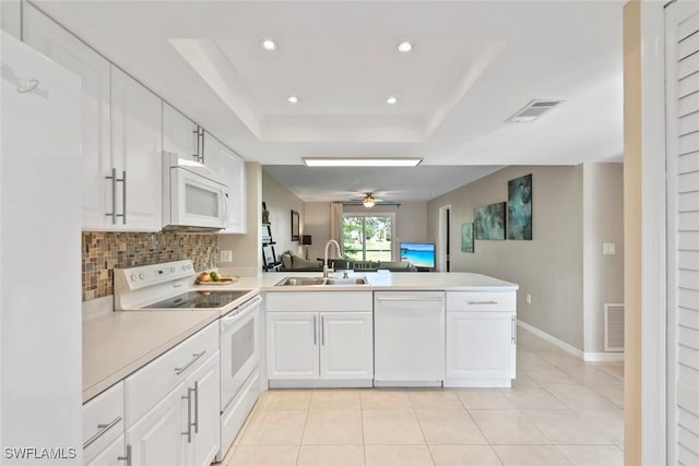 kitchen with recessed lighting, a sink, visible vents, a peninsula, and white appliances