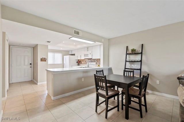 dining room featuring baseboards, visible vents, and light tile patterned flooring
