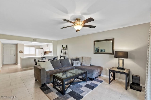 living room featuring light tile patterned flooring, ceiling fan, visible vents, and baseboards