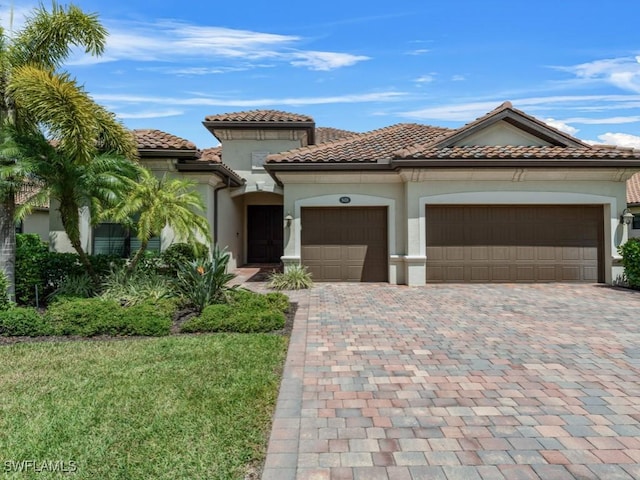 9459 Campanile Cir, Naples, FL 34114 - mediterranean / spanish-style home featuring an attached garage, stucco siding, driveway, a tiled roof, and a front yard