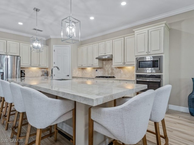 9459 Campanile Cir, Naples, FL 34114 - kitchen with stainless steel appliances, a chandelier, a sink, tasteful backsplash, and light stone countertops