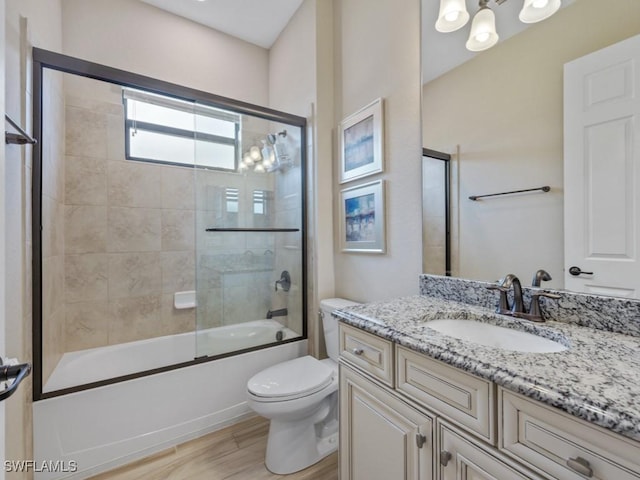 9459 Campanile Cir, Naples, FL 34114 - bathroom featuring wood finished floors, toilet, vanity, and shower / bath combination with glass door