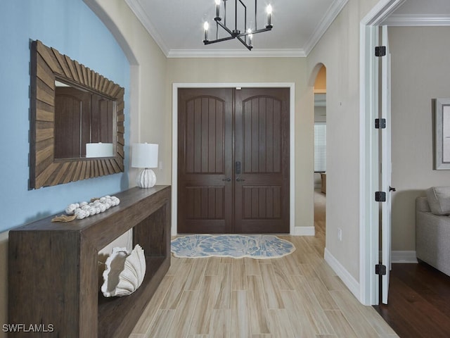 9459 Campanile Cir, Naples, FL 34114 - entrance foyer with arched walkways, crown molding, wood finished floors, and a chandelier