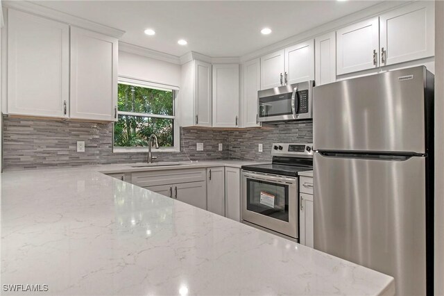 5 Rivard Rd Unit 22, Naples, FL 34112 - kitchen featuring stainless steel appliances, a sink, white cabinetry, backsplash, and recessed lighting