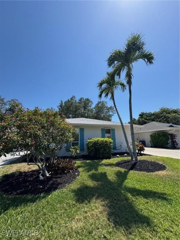 5 Rivard Rd Unit 22, Naples, FL 34112 - view of front facade with a front yard, stucco siding, driveway, and an attached garage