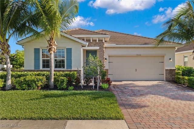 15030 Cortona Way, Fort Myers, FL 33908 - view of front of home with driveway, stone siding, a tiled roof, a garage, and stucco siding
