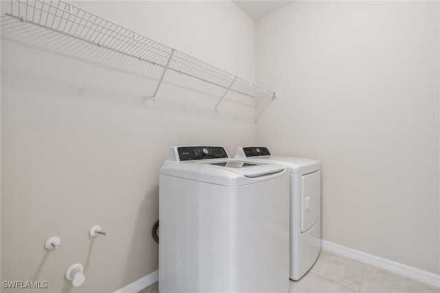 15030 Cortona Way, Fort Myers, FL 33908 - laundry area featuring washing machine and dryer, baseboards, laundry area, and light tile patterned floors