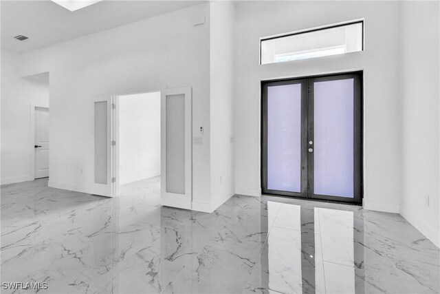 1025 Gladys St, Lehigh Acres, FL 33974 - entryway with visible vents, a towering ceiling, baseboards, and marble finish floor