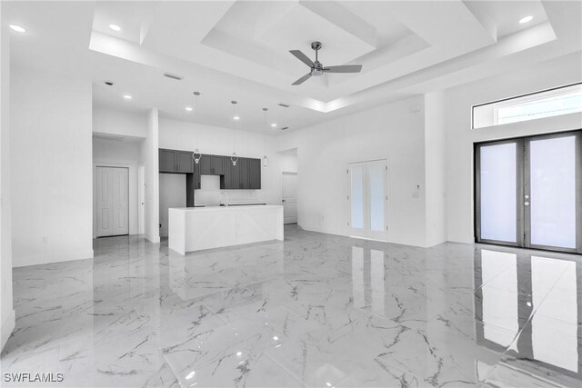 1025 Gladys St, Lehigh Acres, FL 33974 - unfurnished living room with french doors, a tray ceiling, a ceiling fan, a high ceiling, and marble finish floor