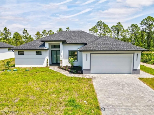 1025 Gladys St, Lehigh Acres, FL 33974 - view of front of property featuring decorative driveway, a shingled roof, an attached garage, a front yard, and stucco siding