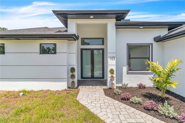 1025 Gladys St, Lehigh Acres, FL 33974 - doorway to property featuring stucco siding, a shingled roof, and french doors