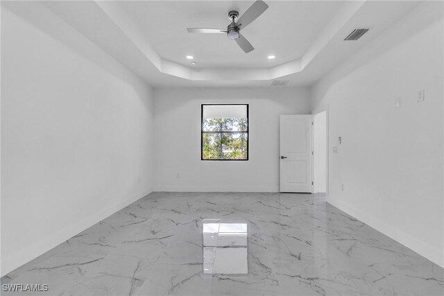 1025 Gladys St, Lehigh Acres, FL 33974 - empty room featuring a raised ceiling, visible vents, marble finish floor, and baseboards