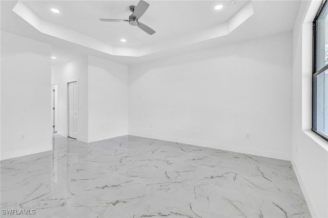 1025 Gladys St, Lehigh Acres, FL 33974 - spare room with recessed lighting, marble finish floor, a tray ceiling, a ceiling fan, and baseboards
