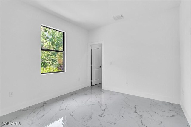 1025 Gladys St, Lehigh Acres, FL 33974 - spare room featuring baseboards, visible vents, and marble finish floor