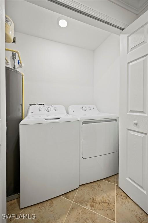 clothes washing area with washer and dryer, laundry area, and light tile patterned flooring