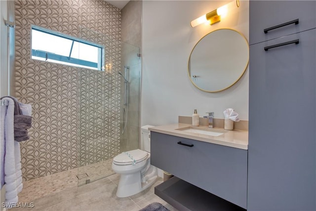 bathroom featuring a walk in shower, vanity, toilet, and tile patterned floors
