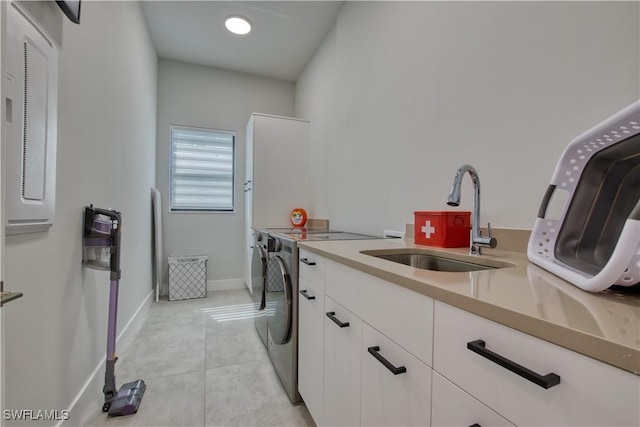 clothes washing area with cabinet space, independent washer and dryer, baseboards, and light tile patterned floors