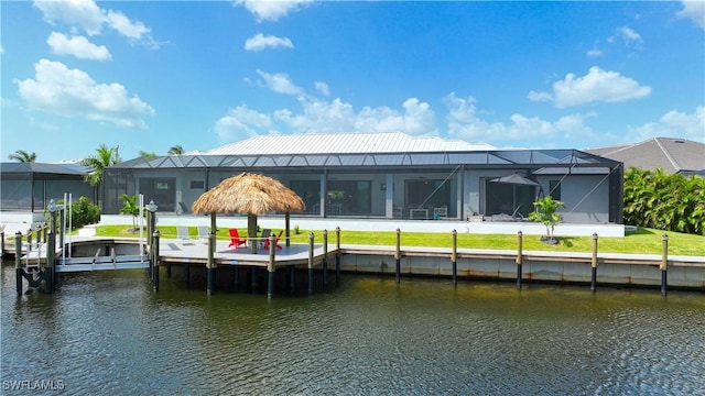 back of property with a water view, boat lift, and glass enclosure