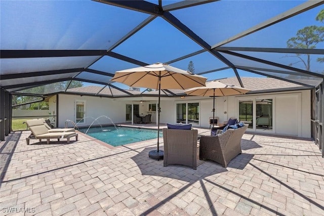 pool featuring glass enclosure, outdoor lounge area, and a patio area