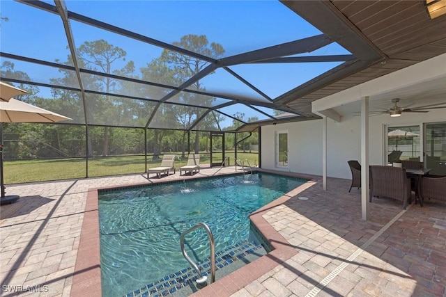 outdoor pool with a lanai, ceiling fan, and a patio area