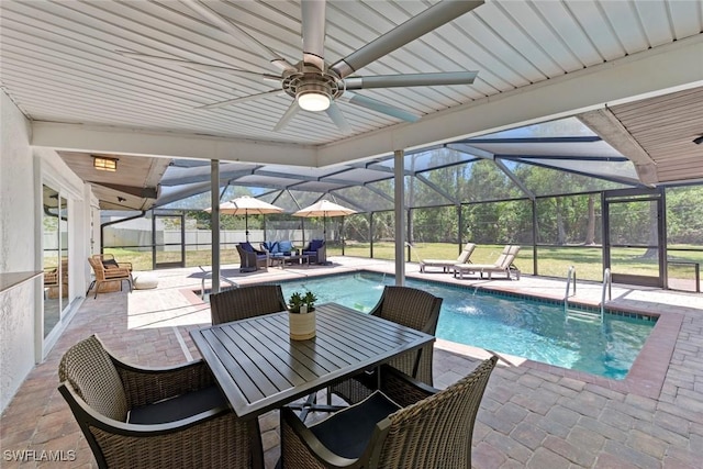 view of pool featuring glass enclosure, a patio, ceiling fan, and a fenced in pool