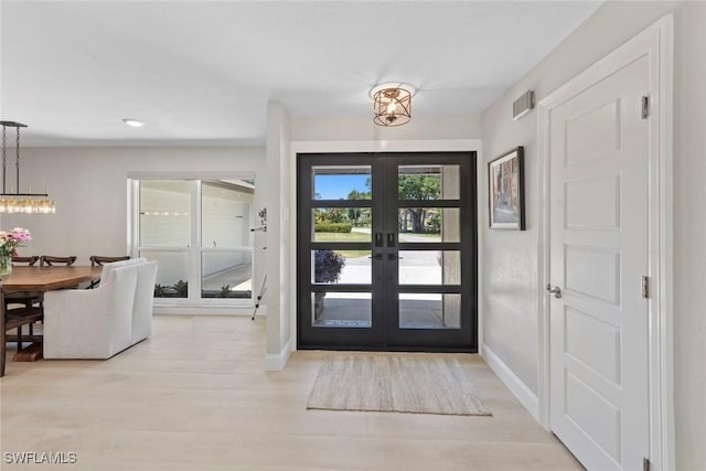 3795 Liberty Sq, Fort Myers, FL 33908 - foyer with a chandelier, french doors, and light wood-style flooring