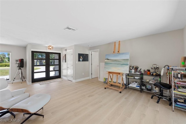 interior space featuring visible vents, light wood finished floors, baseboards, and french doors