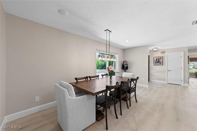 dining room featuring baseboards, visible vents, and light wood-style floors