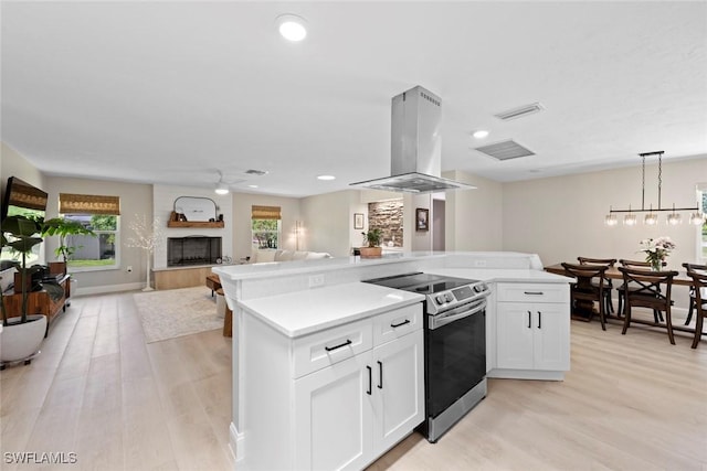 3795 Liberty Sq, Fort Myers, FL 33908 - kitchen with stainless steel electric range oven, island range hood, light wood finished floors, plenty of natural light, and recessed lighting