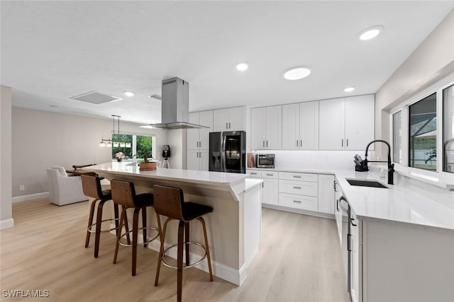3795 Liberty Sq, Fort Myers, FL 33908 - kitchen featuring refrigerator with ice dispenser, island exhaust hood, light wood-type flooring, and recessed lighting
