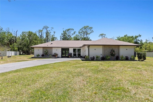 single story home featuring a front lawn, fence, french doors, and driveway