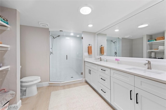 full bath with toilet, a stall shower, a sink, and wood finished floors