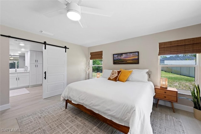 3795 Liberty Sq, Fort Myers, FL 33908 - bedroom featuring a barn door, baseboards, light wood-type flooring, and a ceiling fan