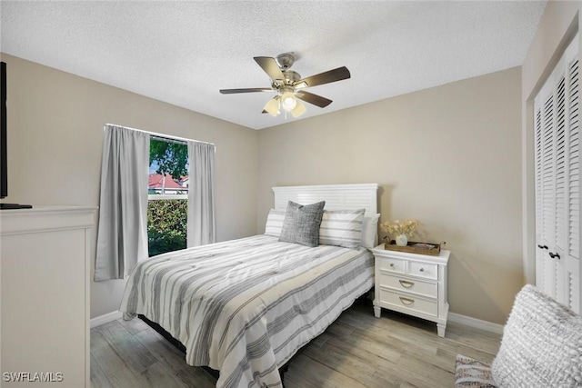 14871 Crescent Cove Dr, Fort Myers, FL 33908 - bedroom featuring baseboards, a ceiling fan, a textured ceiling, and wood finished floors