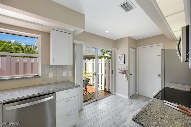 14871 Crescent Cove Dr, Fort Myers, FL 33908 - kitchen with visible vents, light wood-type flooring, white cabinets, appliances with stainless steel finishes, and backsplash