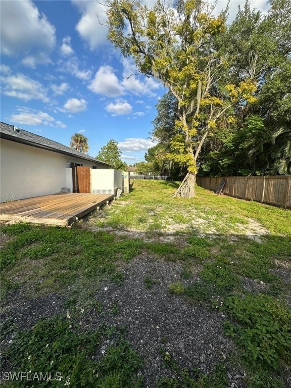 view of yard with fence and a deck
