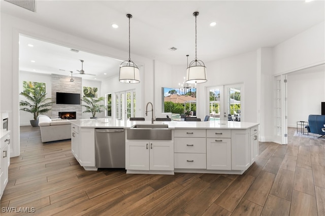 kitchen featuring a sink, dishwasher, open floor plan, recessed lighting, and a fireplace