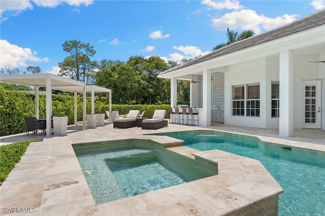 view of swimming pool with a patio and a pool with connected hot tub
