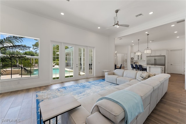 living room with recessed lighting, ceiling fan, french doors, ornamental molding, and baseboards