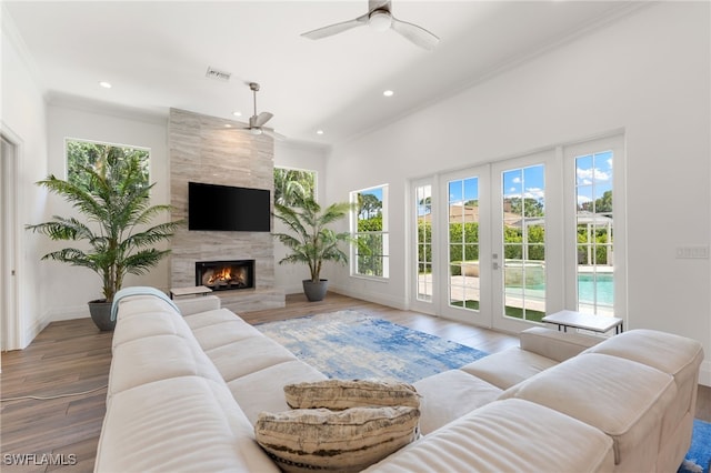 living area with ceiling fan, recessed lighting, wood finished floors, ornamental molding, and baseboards