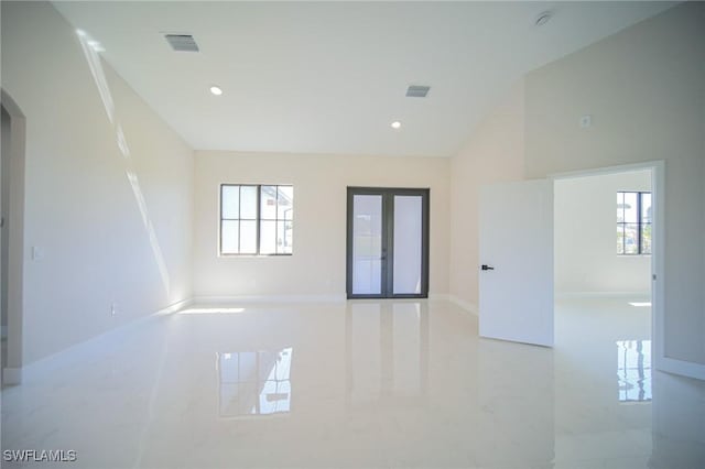 309 Fifth Ave, Lehigh Acres, FL 33936 - tiled empty room with healthy amount of natural light, arched walkways, recessed lighting, and vaulted ceiling