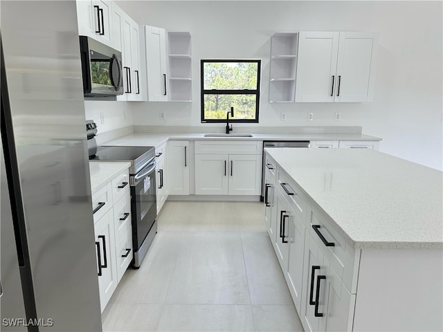 kitchen with a sink, a center island, open shelves, and appliances with stainless steel finishes
