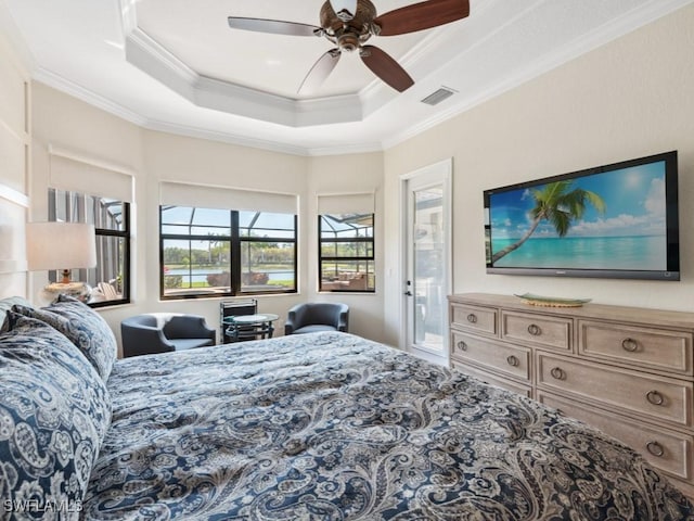 bedroom featuring visible vents, ornamental molding, a ceiling fan, and a tray ceiling