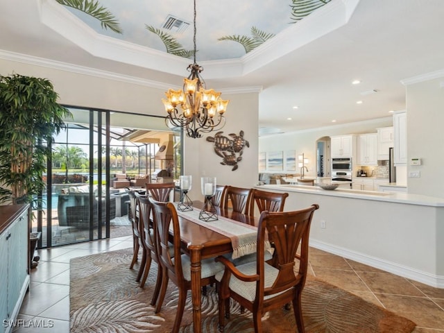 dining space with an inviting chandelier, visible vents, a raised ceiling, light tile patterned flooring, and crown molding
