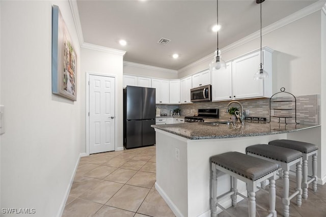 20005 Parrot Key Ct, Estero, FL 33928 - kitchen with visible vents, a sink, dark stone counters, appliances with stainless steel finishes, and white cabinetry