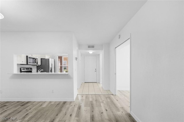 5731 Foxlake Dr Unit 1, North Fort Myers, FL 33917 - corridor featuring baseboards, visible vents, and light wood-type flooring