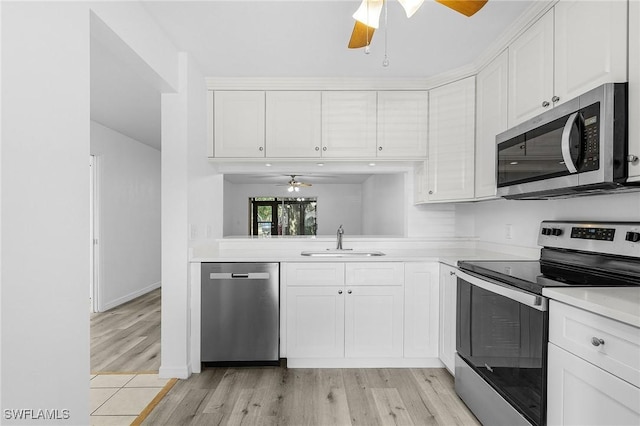 5731 Foxlake Dr Unit 1, North Fort Myers, FL 33917 - kitchen with light wood-style flooring, appliances with stainless steel finishes, light countertops, a sink, and a ceiling fan