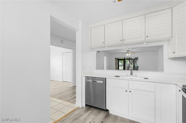 5731 Foxlake Dr Unit 1, North Fort Myers, FL 33917 - kitchen with stainless steel dishwasher, light countertops, a sink, white cabinetry, and light wood-type flooring